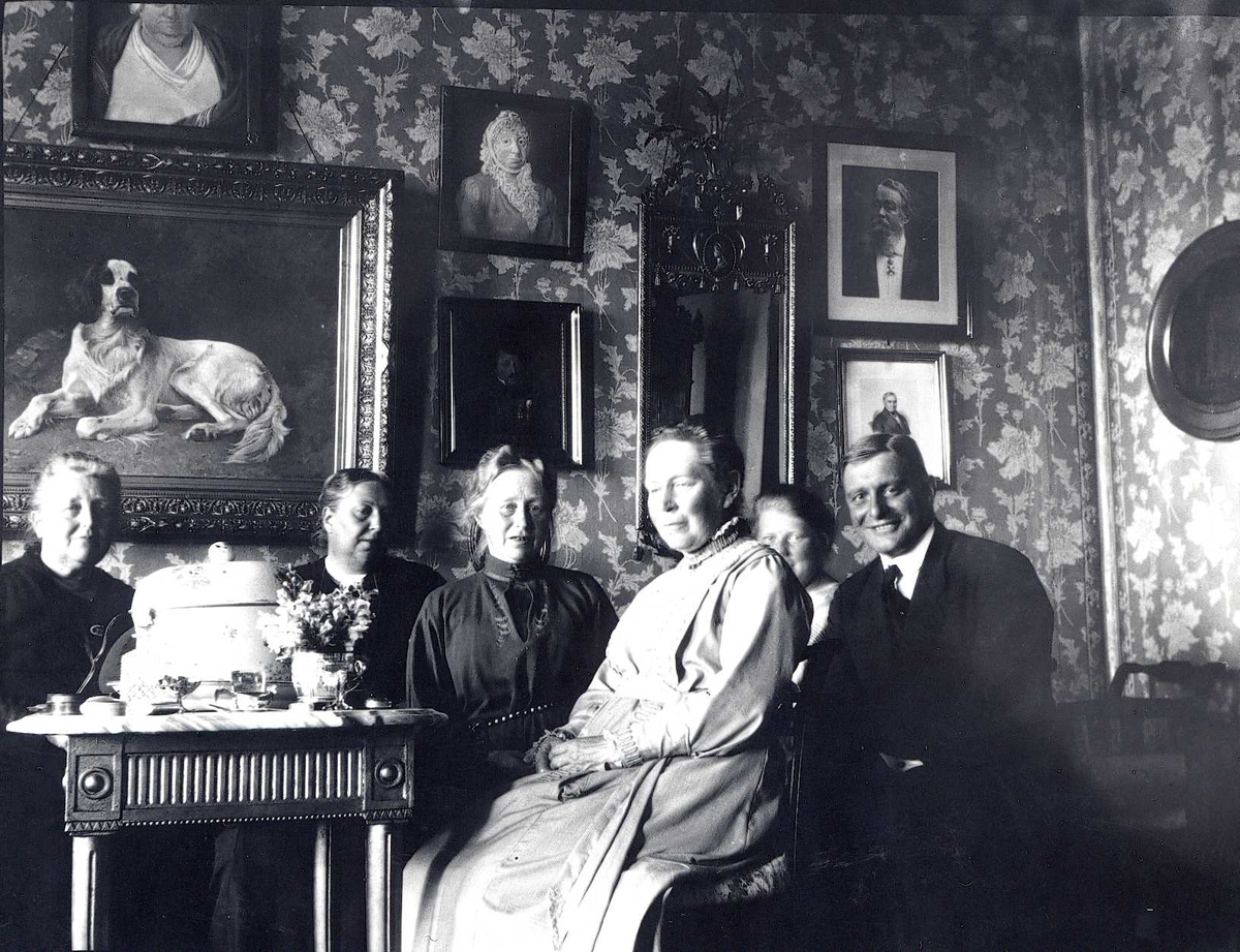 Cappelen familieportrett i interiør med kunst av Karl Uchermann på veggen.