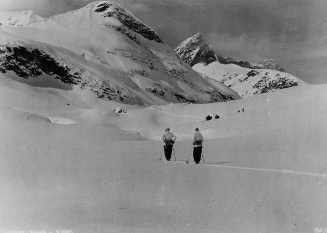 Avfotografert postkort.To skiløpere i fjellet.