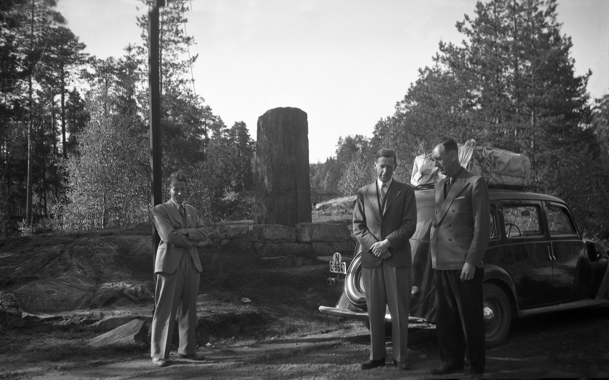 Tre menn på vei til Nordisk Ingeniørmøte i Stockholm. En bil og en milestein står i bakgrunn.  Fotografert 1946.