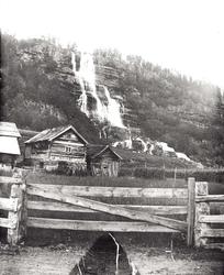 Tvindefoss, Tvinde, Voss. Jorder, gjerder og gårdshus foran.