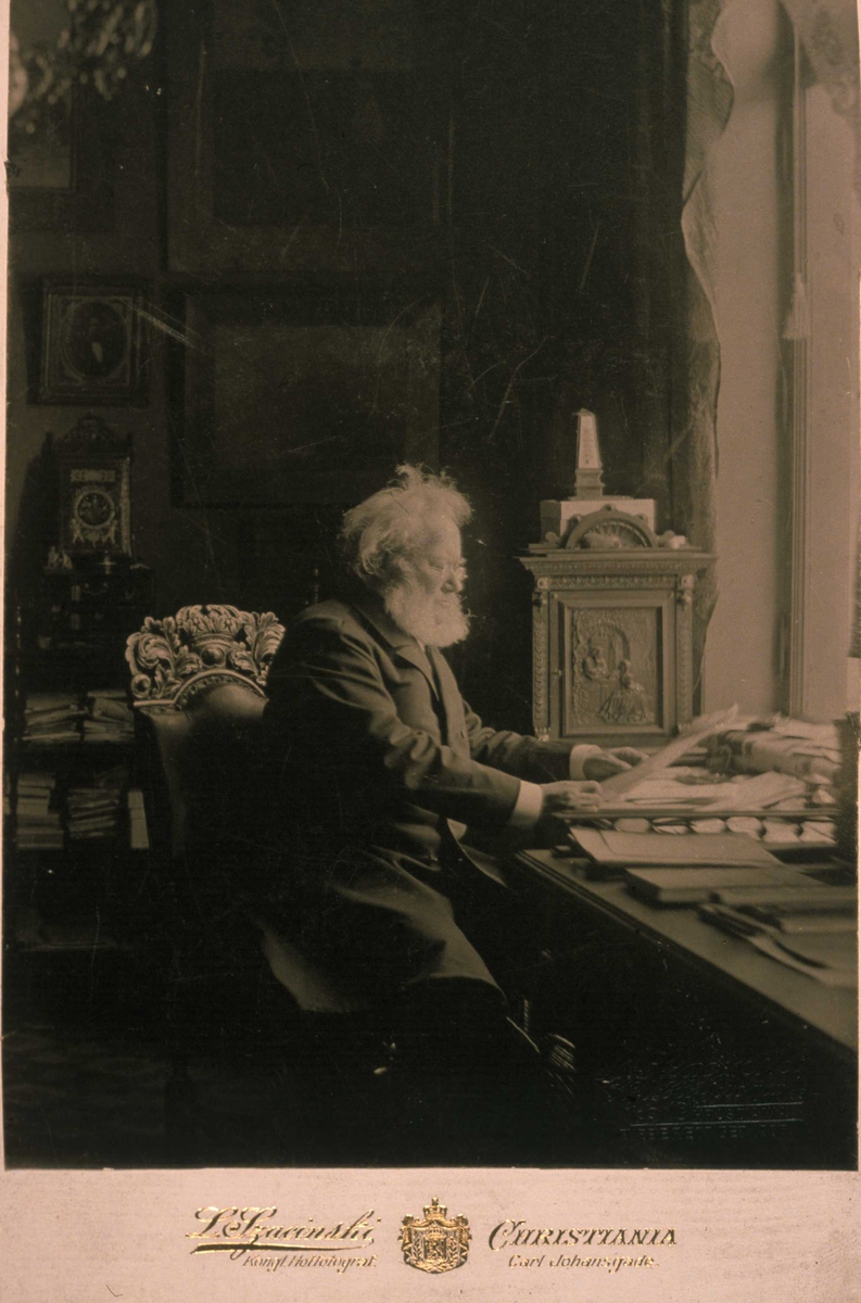 Henrik Ibsen ved skrivebordet i sitt arbeidsværelse i Arbins gate i Oslo. Fotografert mellom 1895 og 1906.