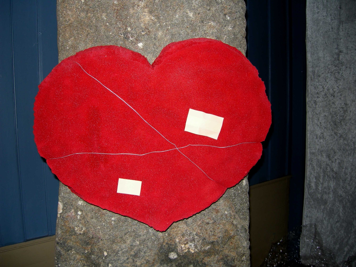 Allehelgensdag i Oddernes kirke 04.11.2007. Detalj fra installasjon i våpenhuset laget av Anne Kristine Jakobsen og Anne Margrethe Vihovde. Et rødt hjerte med ståltråd og plaster.