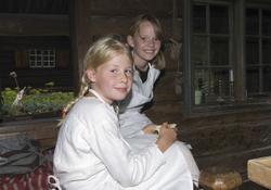 Levendegjøring på museum.
To jenter i eldhuset i Numedal.