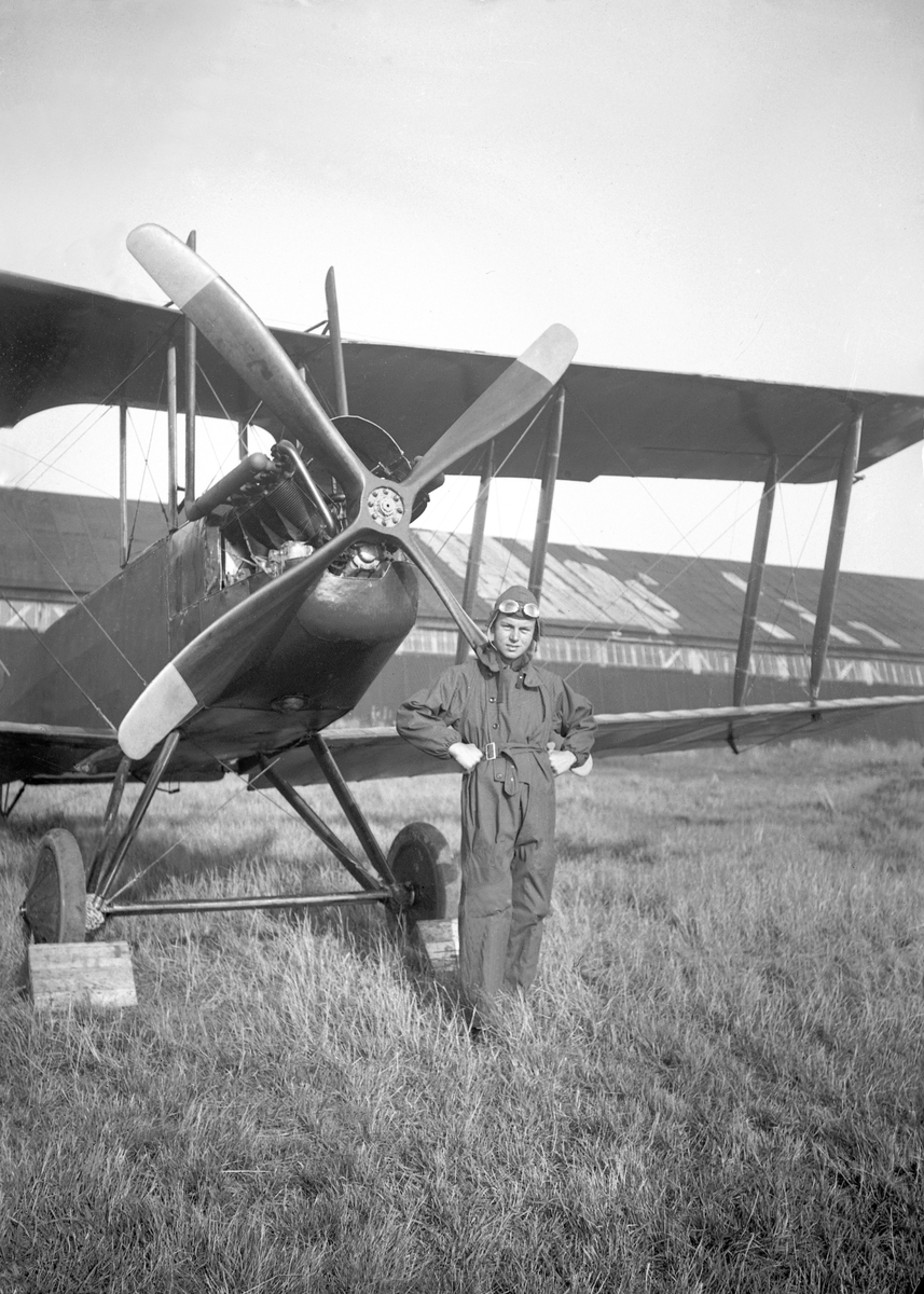 Flyveren Bjarne Arentz foran flyet. Hangaren i bakgrunnen. Bjarne Arentz omkom i flyulykke 22 år gammel.