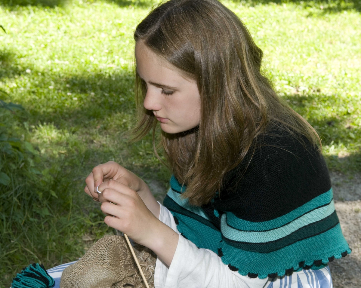 Jente med strikketøy utenfor skolestuen.
Ferieskolen uke 26, 2009..
