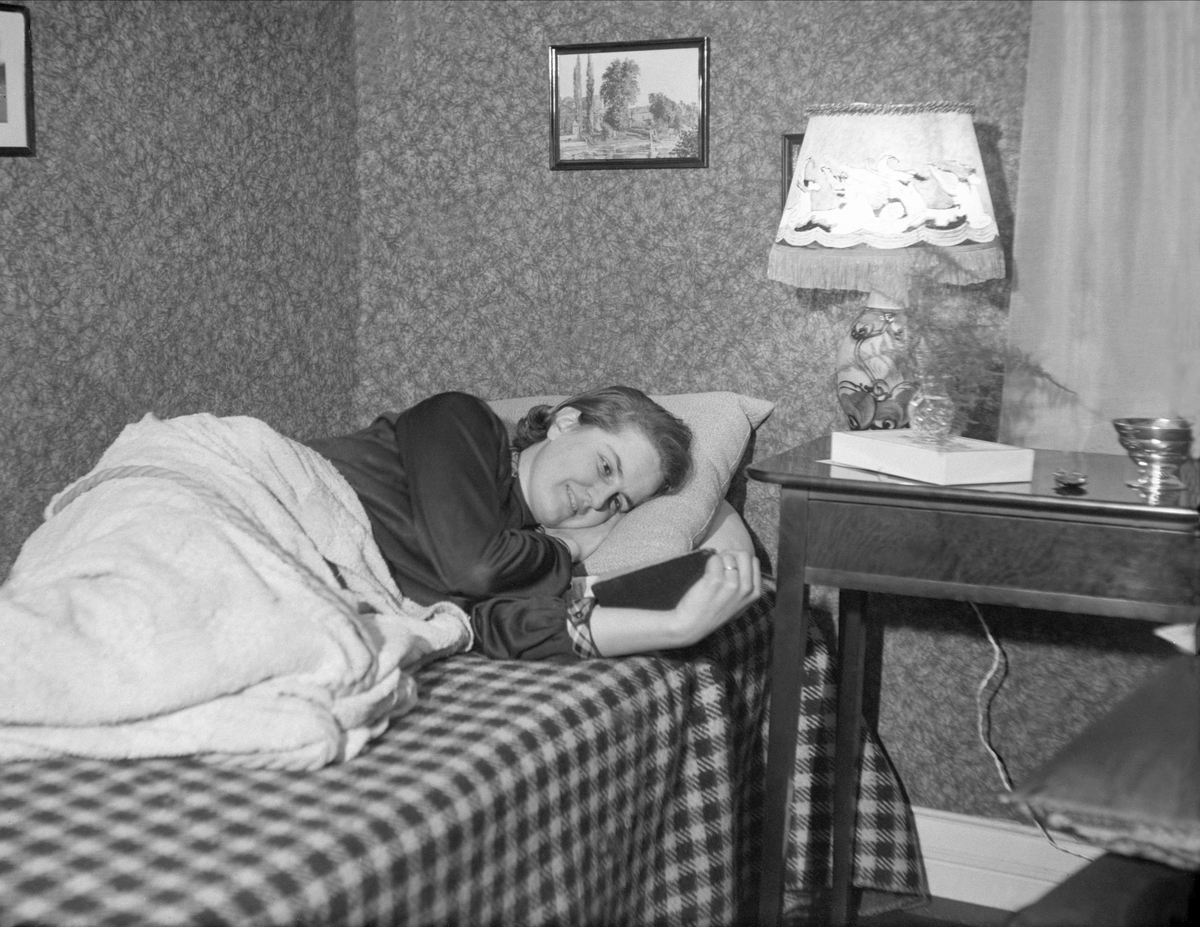 En nygift Dordi Arentz ligger på sofaen og leser. Fotografert november 1927.