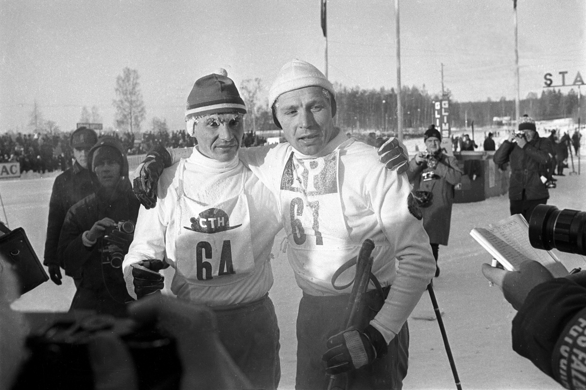 Slitne skiløpere etter målgang blir fotografert av pressefotografer.  Svenska Skispelen i Falun i 1967.