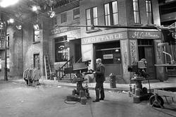 Kulisser fra engelsk gatemiljø i fjernsynsstudio. Kameramann