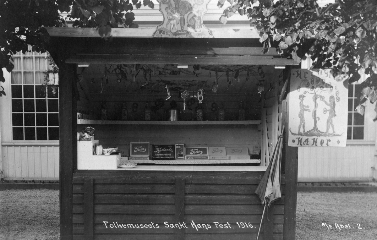 Postkort. Markedsbod med salg av kringler, kaker og sjokolade. Norsk Folkemuseums St. Hansfest 1916.