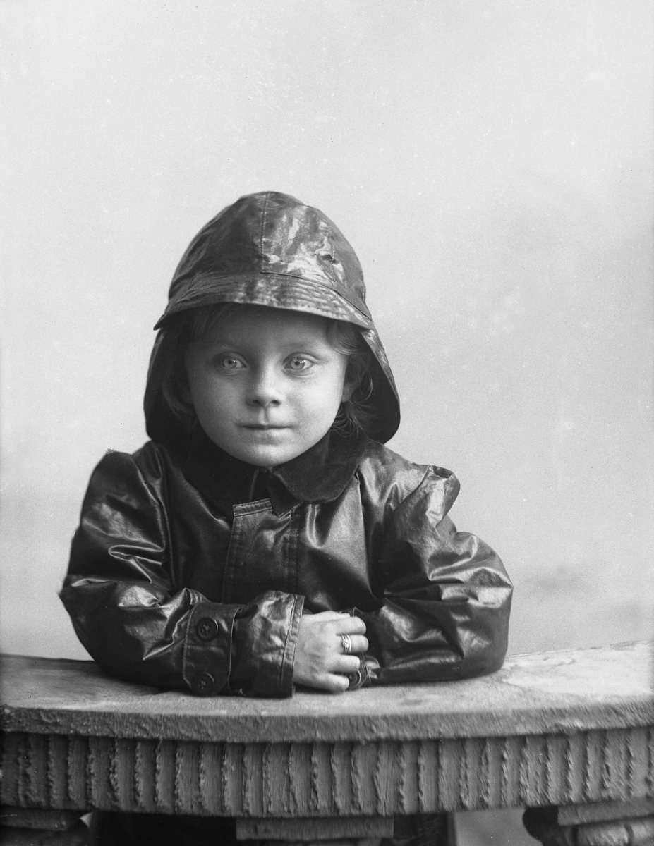 Portrett, gutt i regntøy og sydvest.