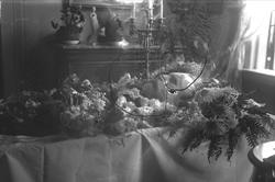 Post mortem-fotografi. Død mann i kiste pyntet med blomster