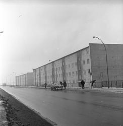 Bil av typen Volvo parkert ved bussholdeplassen utnfor blokk