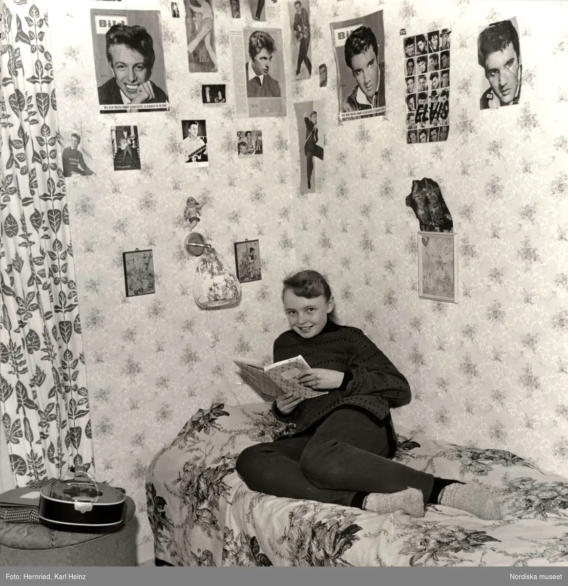 Tonårsflicka i sitt rum. Idolbilder på Tommy Steele och Elvis Presley på väggarna. 