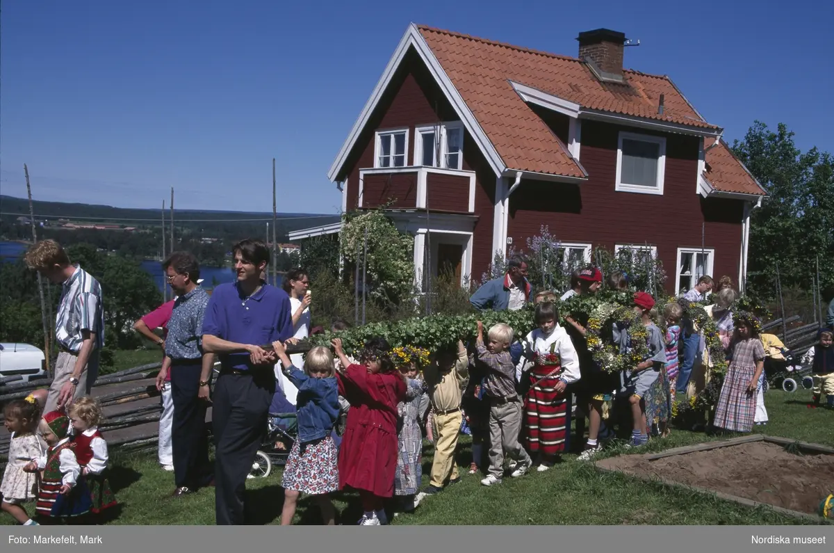 Midsommar. Dalarna. Midsommarafton vid Jöns-Andersgården i Rättvik. Barnen bär majstången.