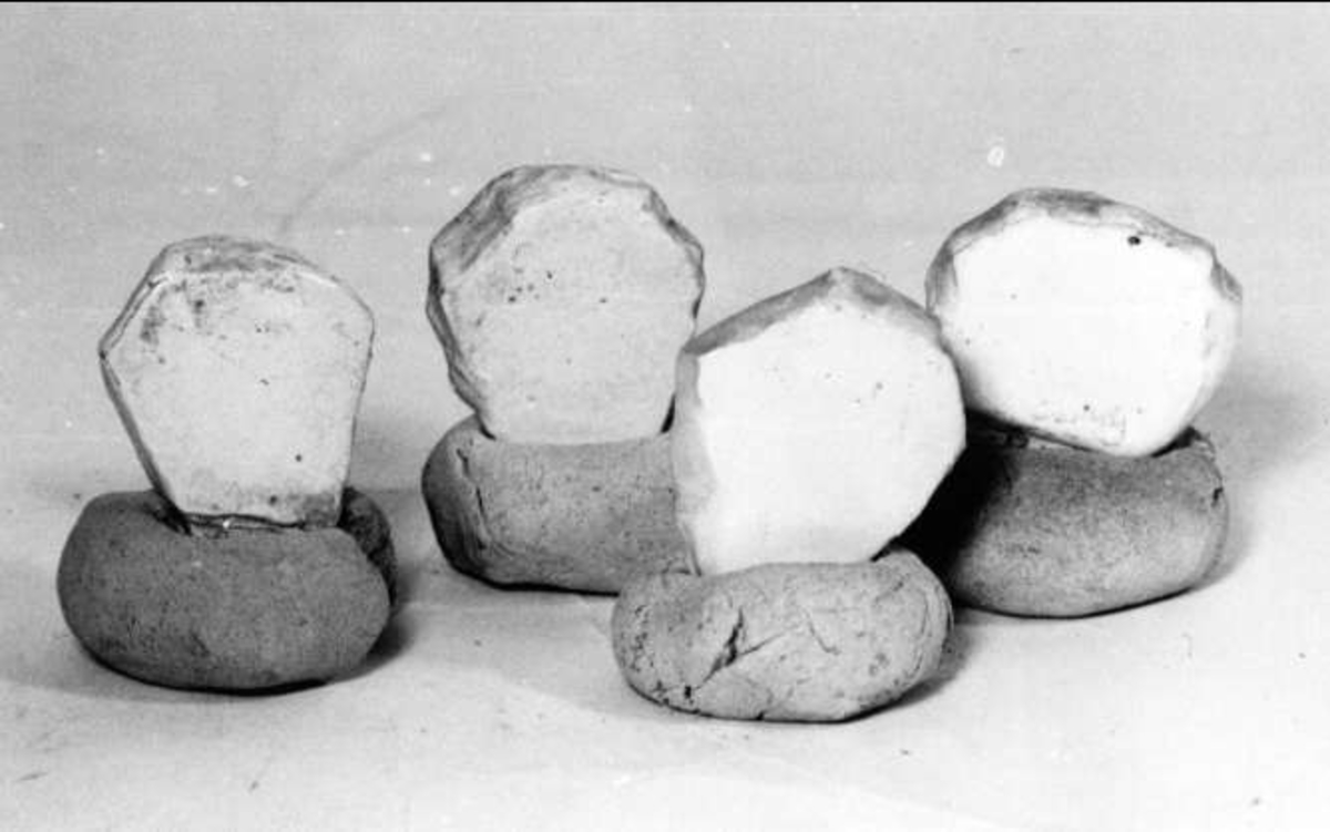 Fyra dockor, vitglaserade lergodsbitar nedstuckna i en rund lerklump. Proverna användes i ugnen för att se när glaserade föremål var färdigbrända. Dockan stod i en burk av lergods (UM 17499) vid en av tittgluggarna och lyftes ut med en järnstång (UM17500 eller UM17501) för att kontrollera om det var glans på dockans glasyr. Dessa dockor är prov på vit kakelglasyr.