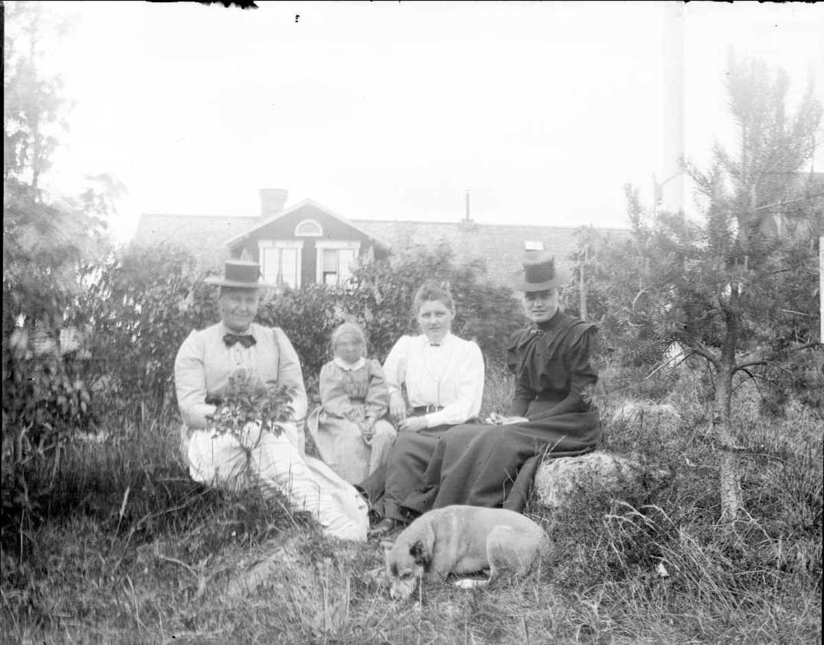 Augusta Lundin och dottern Hedvig Helena, lärarinnan Malin och en kvinna i hatt, sannolikt framför lanthandeln i Ärnevi, Funbo socken, Uppland
