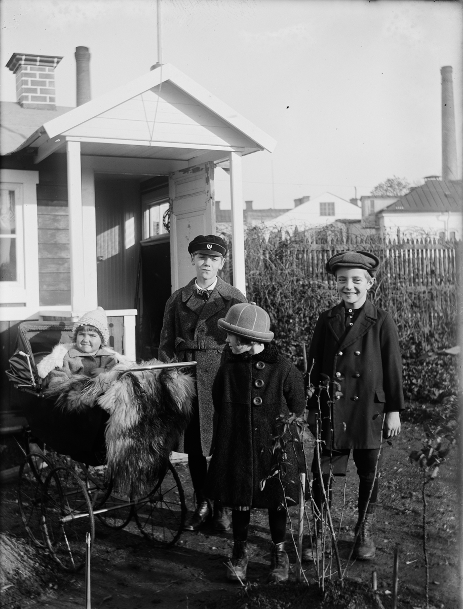 Kalle, Rolf, Inga-Britt och Ella Ärnström vid familjens kolonistuga, nuvarande kvarteret Luthagsstranden, Luthagen, Uppsala, sannolikt 1924