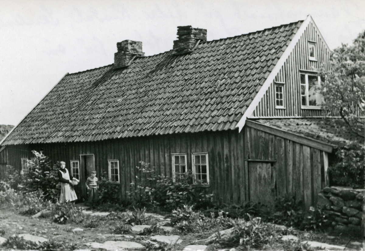 Våningshus på Nedre Risdal. Kvinne og barn foran huset.