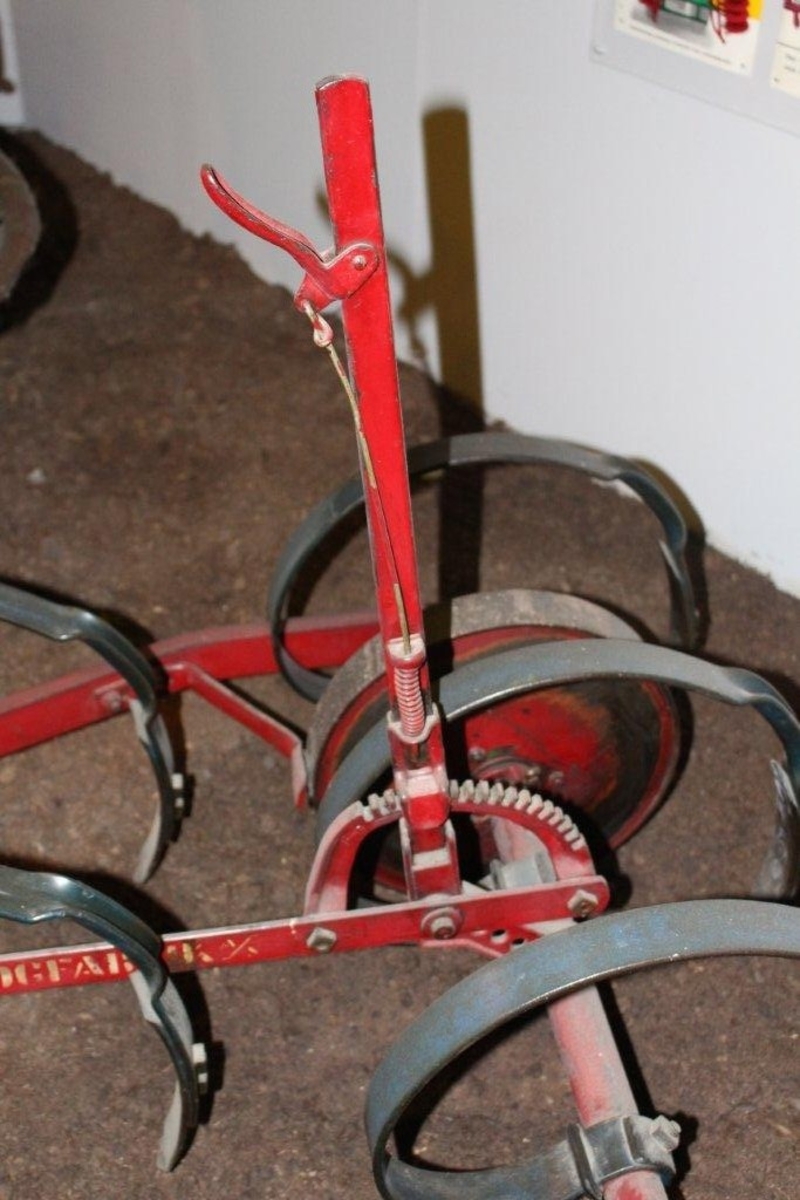 Ramme av vinkeljern. 9 tinder i 3 rader. To hjul i bakre rad, et mindre hjul fremme. Håndtak for regulering av arbeidshøyden.
