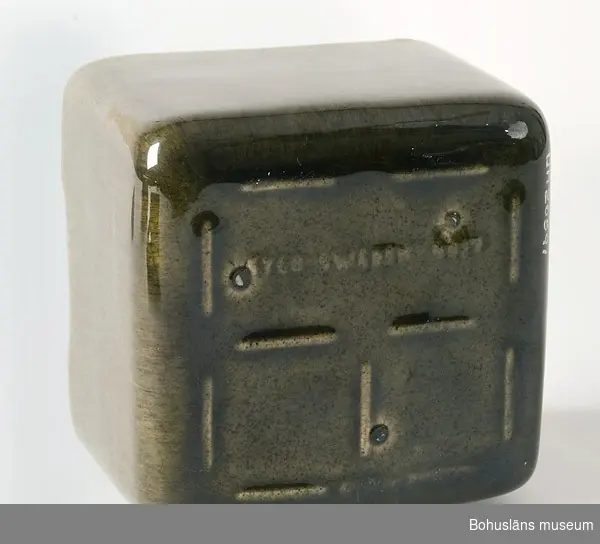 Rektangulär, grönglaserad smörask med brunglaserat lock. 
Märkt i botten med signatur: "SYCO Sweden 4097."