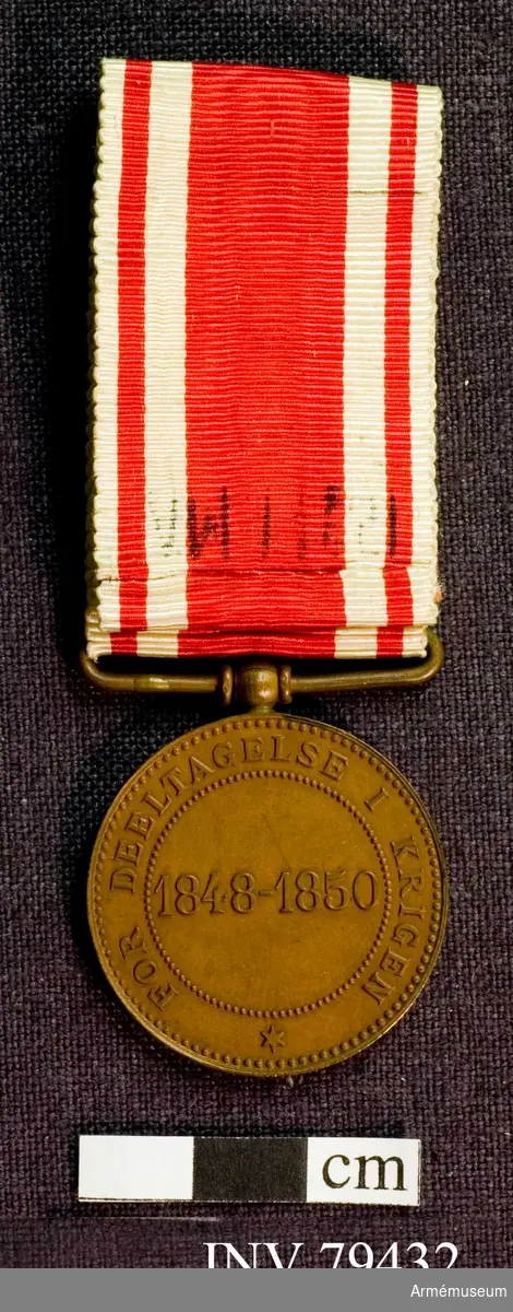 Grupp M.

Åtsidan: FREDERIK VII KONGE AF DANMARK. Konungens huvud åt höger, bart. Under: ALPHÉE DUBOIS, allt omgivet av en pärlband.

Frånsidan: ytterst: en pärlband; där i: FOR DELTAGELSE I KRIGEN, ytterligare ett pärlband; innerst: 1848-1850.

Medaljen har fastlödd och rörlig bandhållare.
Bandet: röd rips med å vardera sidan två smala, vita ränder av olika bredd, den smalaste ytterst.
