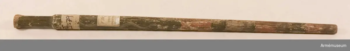 Stång bemålad med rosa och grönt och vita slingor. Etikett från Riddarholmskyrkan "No 874 K(?)" samt etikett med text som anger att standaret är taget under Karl XII:s befäl vid Jakobstad.