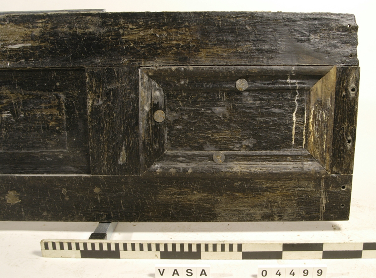 Bänkpanel till en kistbänk från kajutan. Panelen utgör hela bänkfronten och består av ett ramverk och tre spegelfyllningar med profilerade lister runt om.