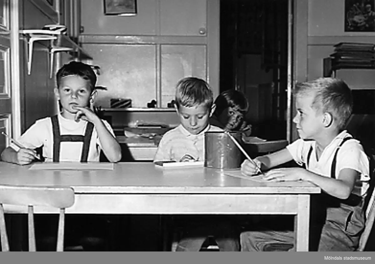 Några barn som sitter och ritar vid Holtermanska daghemmet 1953.