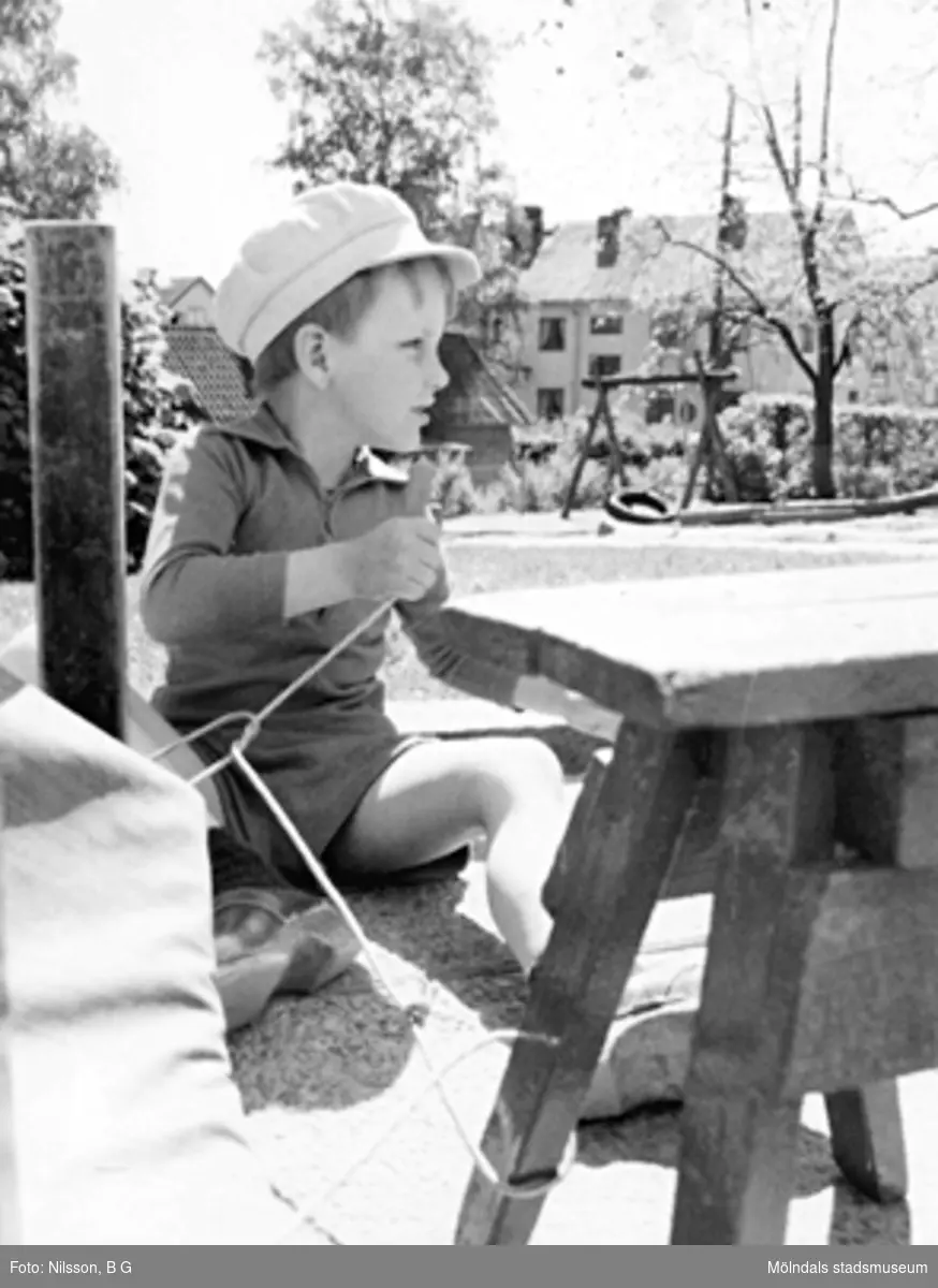 En pojke som sitter utomhus. Holtermanska daghemmet, okänt årtal.