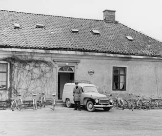 Postkontoret Djursholm 2, Östra slottsflygeln. Framför entrén förste
postiljon Assar Svensson. Bilen är en Volvo Duett, årsmodell 1960-1962.