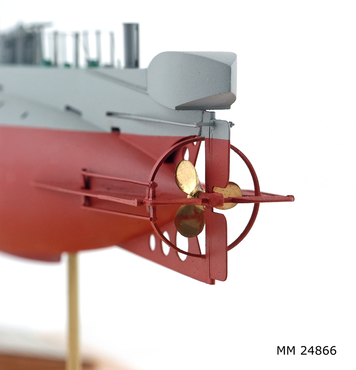 Ubåtsmodell Hajen i monter. Modell av alträ med detaljer av mässing, målad med cellulosafärg. Rött och grått skrov. Monter av plexiglas på träplatta. Mässingsbricka i montern med uppgifter om modellen.