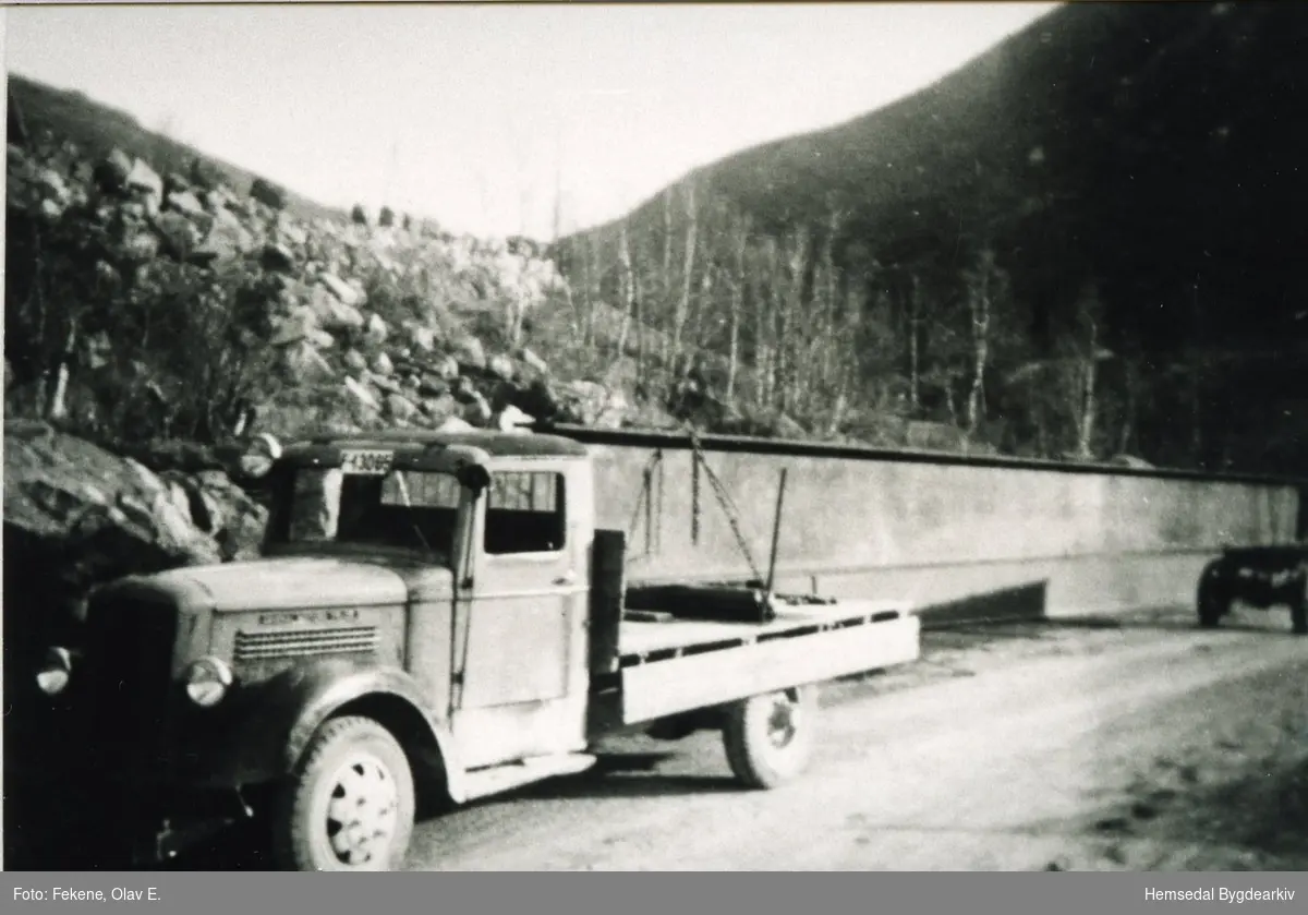 Olav E. Fekene transporterer jernbjelkane til Skøyten bru i Hemsedal i 1938.
Bjelkane var 21 meter lange, 1 meter høge og vog 6,7 tonn kvar.