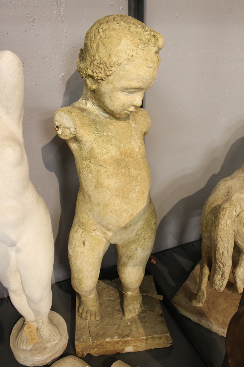 Skulptur i gips av et pikebarn. Uviss tittel. "PIKEBARN" eller "FØRSTE SKRITT". Se også nr.107.