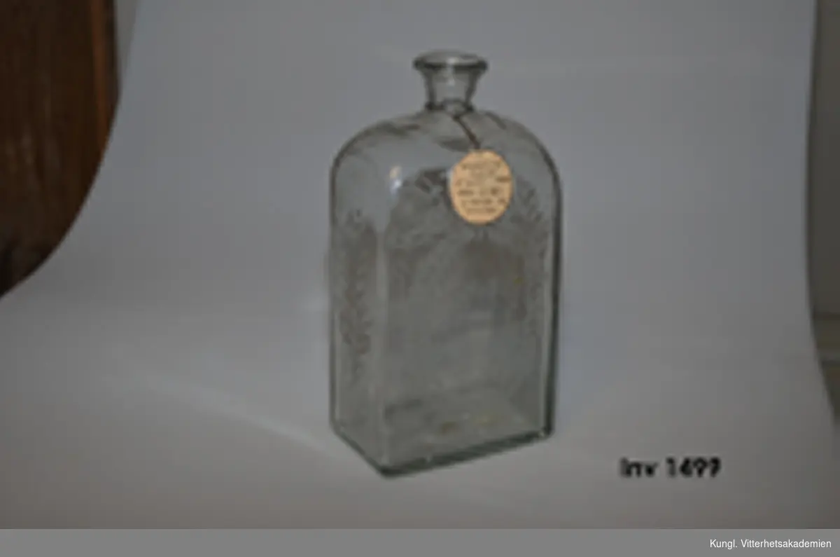 Flaska för brännvin av glas med årtalet 1824  ingraverad.  Ornerad med blom- o. bladrankor på alla sidor.  Bokstäverna  A: G: L: B: ingraverade  på frontsidan.

 fr.Nyby, Stafbv sn. Uppland