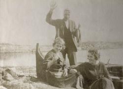 To kvinner og en mann foran en nordlandsbåt. Mannen holder e