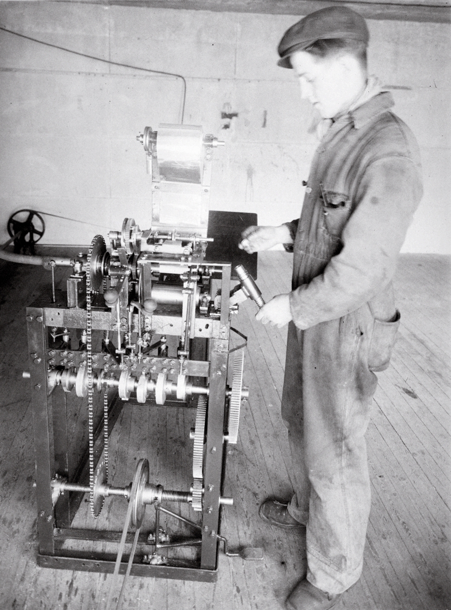 Mann betjener maskin ved hyssing fabrikken i Gamlebyen.
