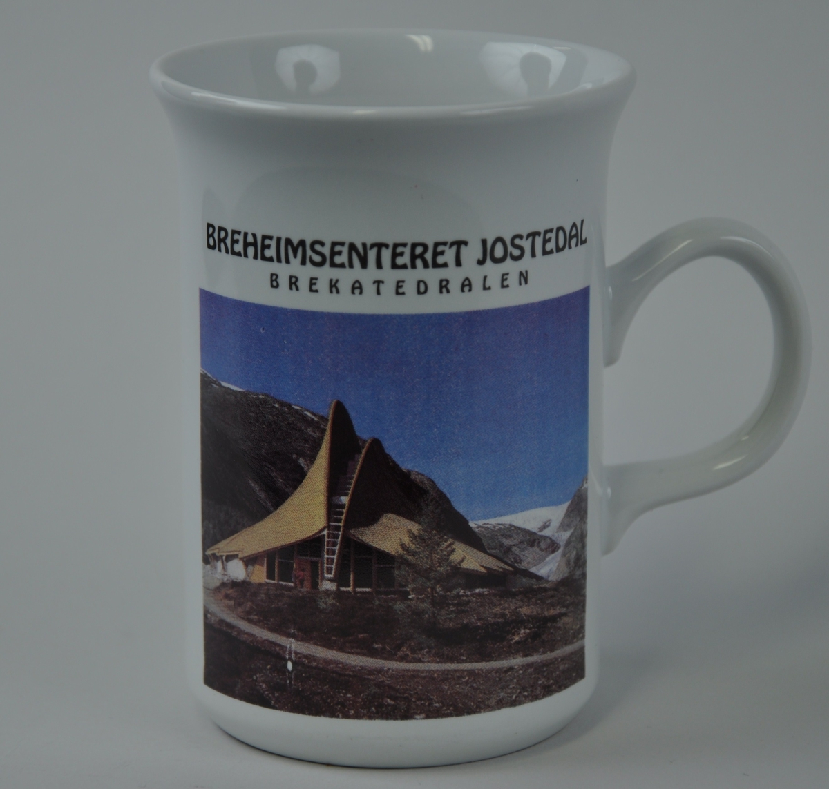 Eit foto av breheimsenteret i Jostedal med fjell og breen attom.