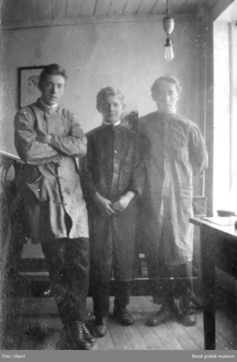 Tre menn i frakk poserer for fotografen, på Dreyers Reproduktionsanstalt. F.v.: Trygve Berge, Olaf (ukjent etternavn), Jakob Roalsvig.

Albumtekst:
"Tre forskjellige størrelser i alle retninger"