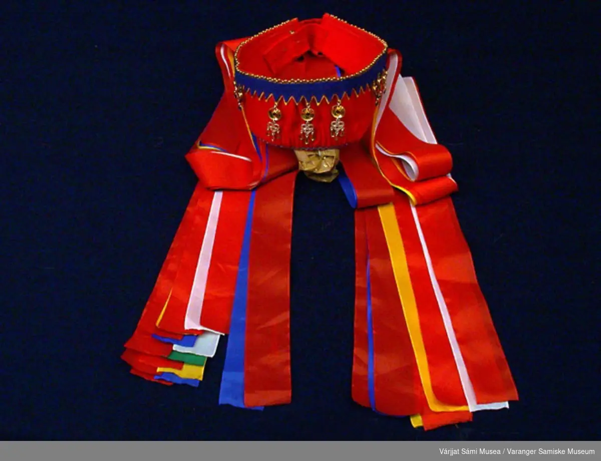 Brudekronen er sydd av rødt klede og pyntet med blått klede. Silkeband i rød, hvit, gul, blå, grønne farger. Sølvanheng. Brudekronen er lagd slik at den kan justeres mht størrelse.