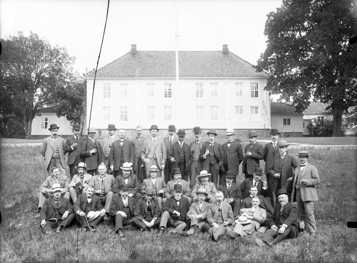 En gruppe menn ved Søndre Brekke Gård fotografert