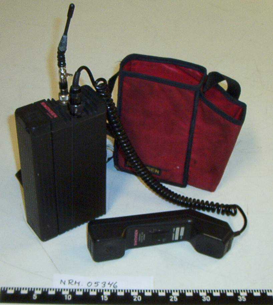 Type 751-50.
Mobiltelefon for UP's sambandsutstyr med tilhørende rød bæreveske.
Vesken inneholder også bruksanvisning.