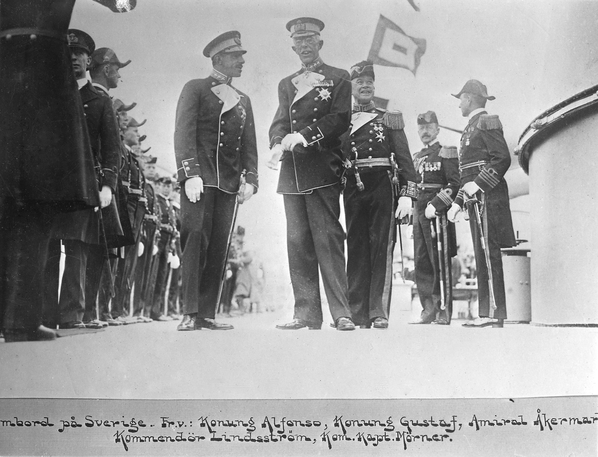 [textat på monteringsbas under det avfotograferade fotografiet:] "Ombord på Sverige. Fr.v.: Konung Alfonso, Konung Gustaf, Amiral Åkermark Kommendör Lindsström, Kom.Kapt. Mörner."