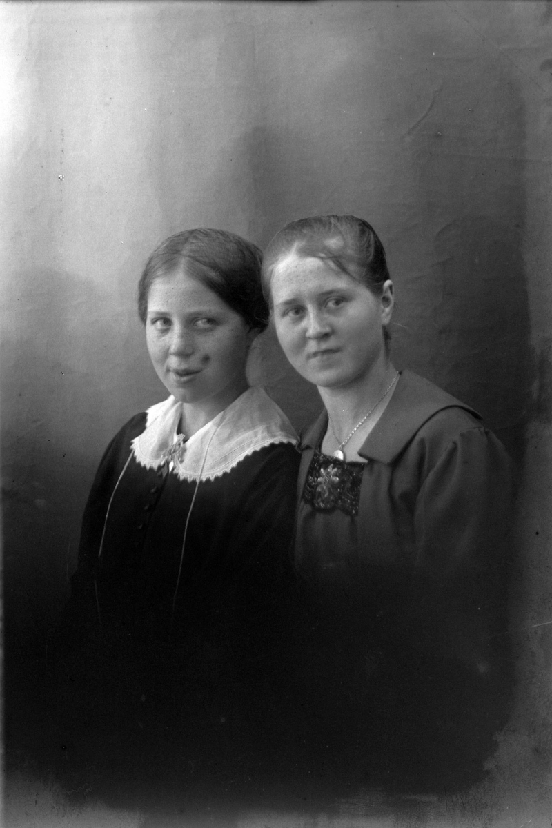 Studioportrett av to unge kvinner.