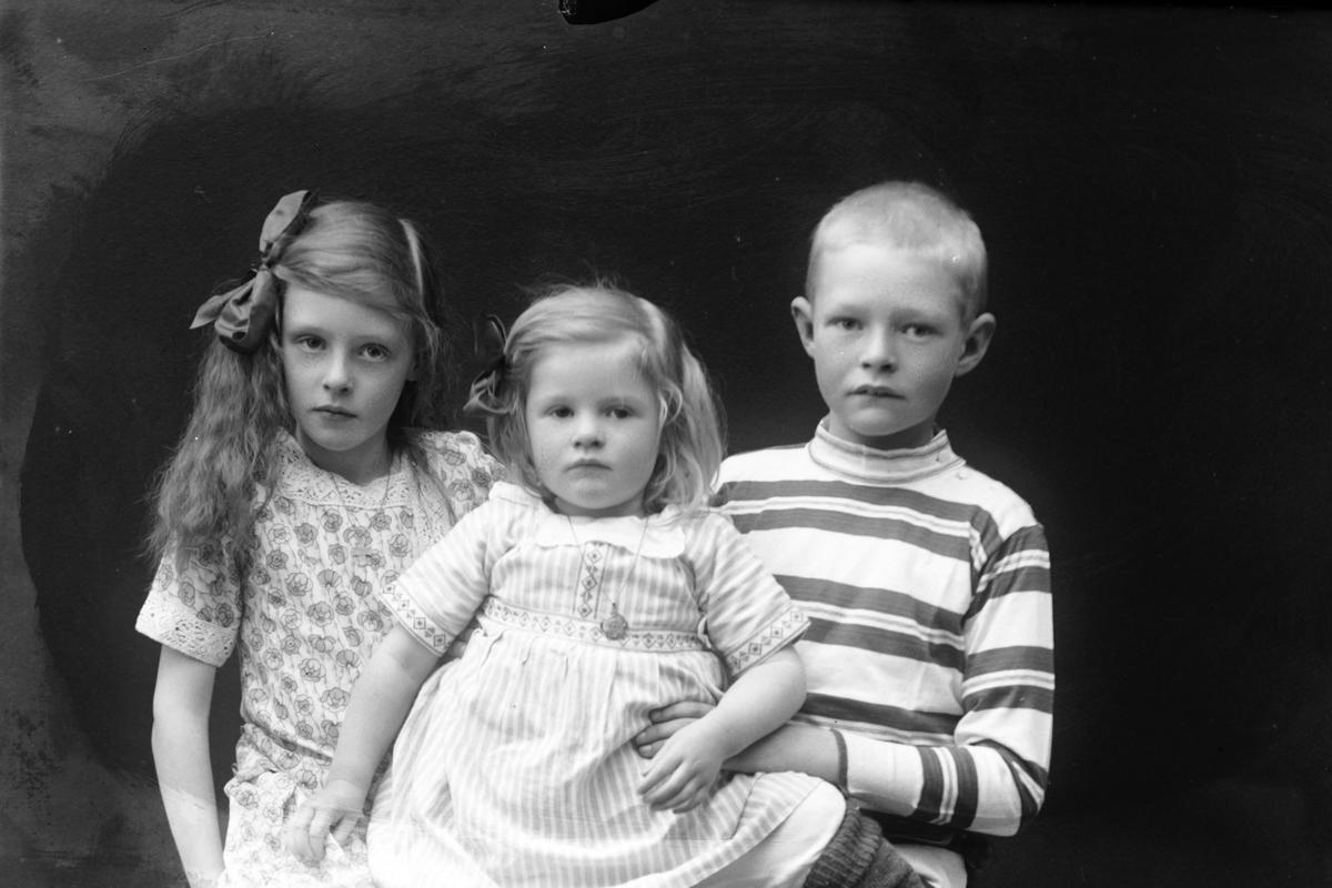 Studioportrett av tre barn i halvfigur.