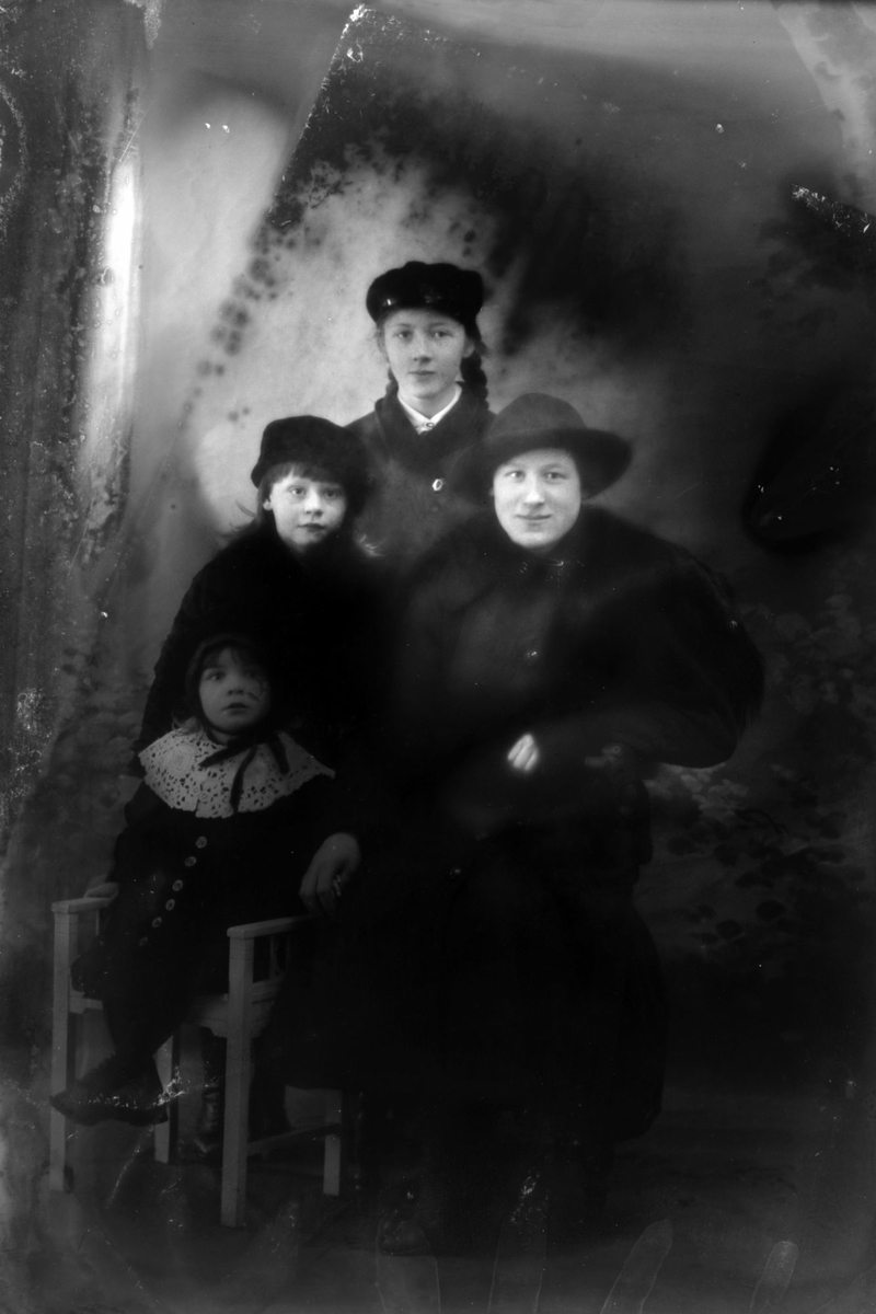 Studioportrett av en kvinne med tre barn.