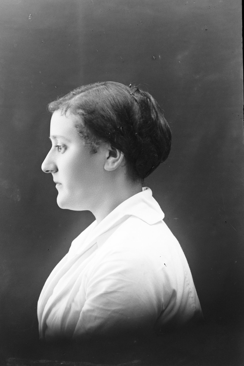 Studioportrett av en kvinne sett i profil.
