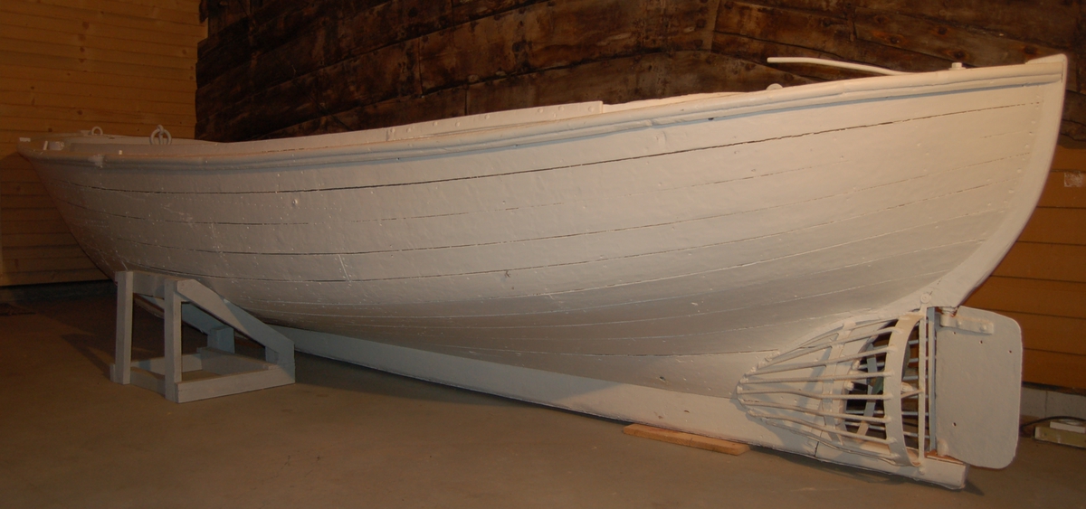 Snekkeliknande kravellbygd trebåt med eikespant, utstyrt med bensinmotor og årer til framdrift.
Til beskyttelse av propellen mot skader fra isklumper, er den omgitt av en "korg" av rundtjern.
