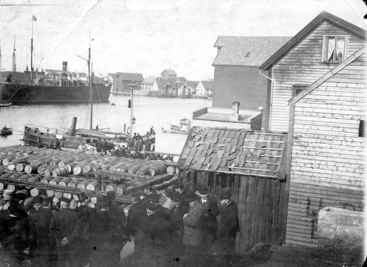 Dagen etter brannen på Torget i 1899. Dampskipet ved Kortanes er "Munin" (Stolt Nielsen). Husene er, helt til h. P. Amlie's, (uthuset). og bak det T. Østensjø's hus,Torvet, sjøhuset er på nordsiden av Torvet."