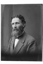 Studioportrett av en mann med langt skjegg.