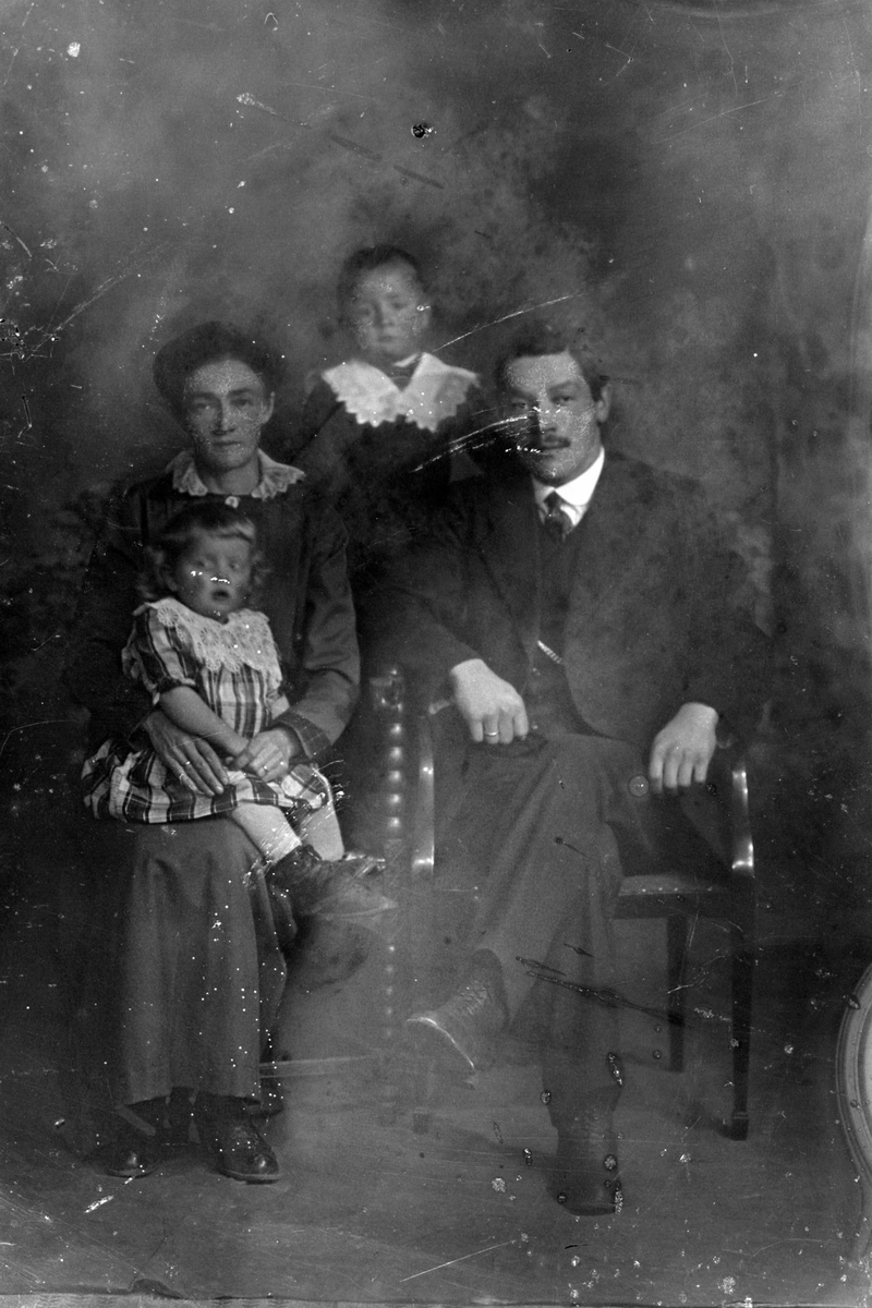 Studioportrett av en mann og kvinne med to barn.